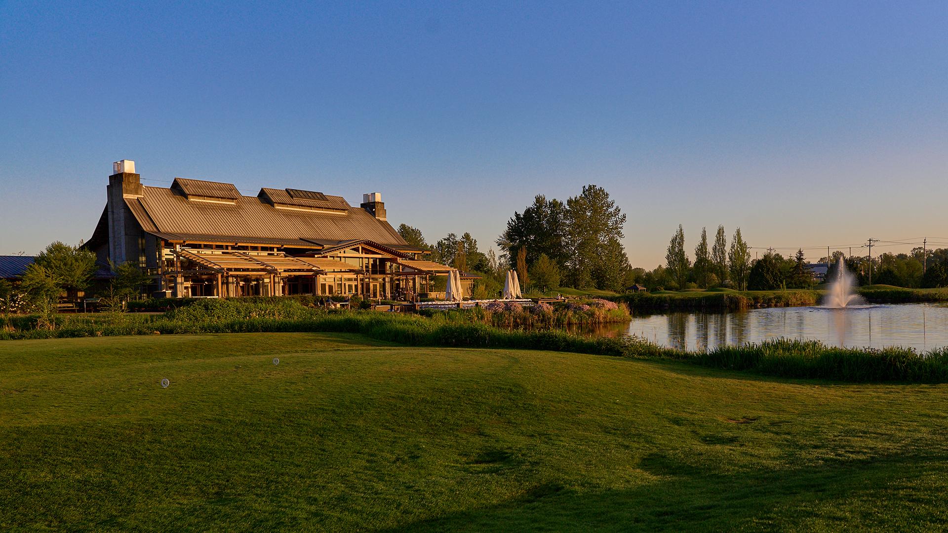 Building in front of a stilll lake at sunset
